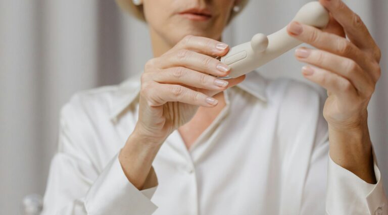 Photo par cottonbro studio A mature woman examines a cream-colored personal wellness device indoors.
