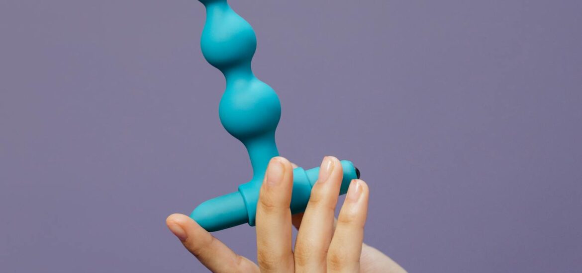 Photo par cottonbro studio Close-up of a hand holding a purple silicone toy against a purple background.