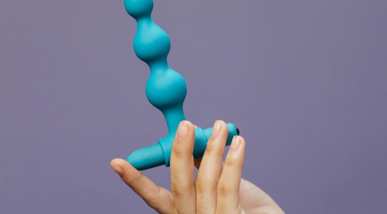 Photo par cottonbro studio Close-up of a hand holding a purple silicone toy against a purple background.
